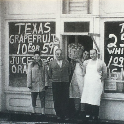 group of men standing in front of grocery store