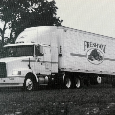 Black and white semi truck with Freshway logo on the side